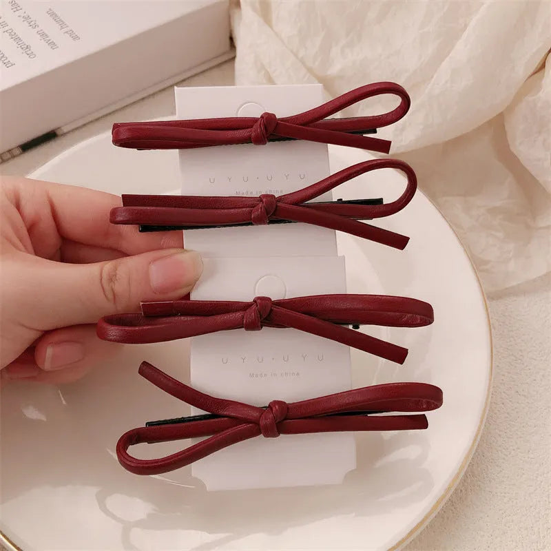 Wine red genuine leather bow hair clip barrette on a white background.
