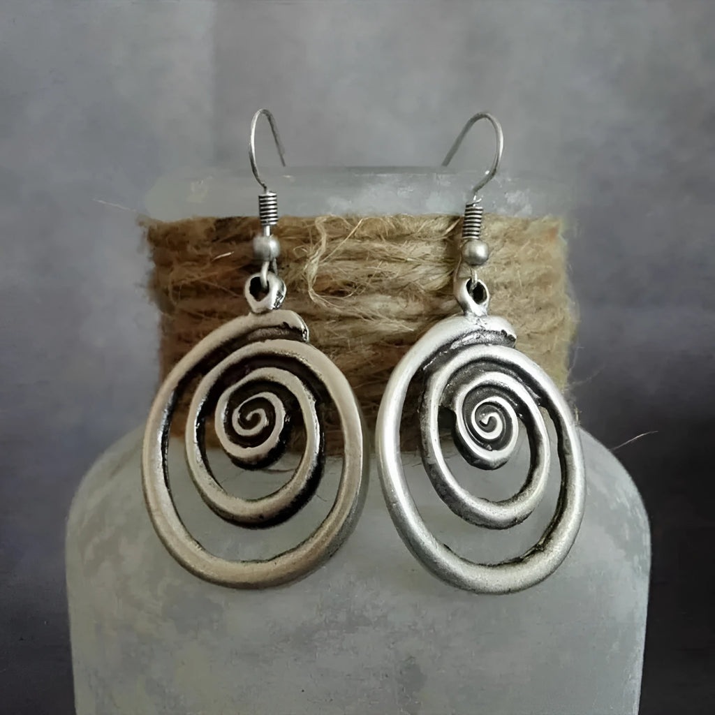 A pair of retro-style geometric spiral earrings with a distressed silver finish.