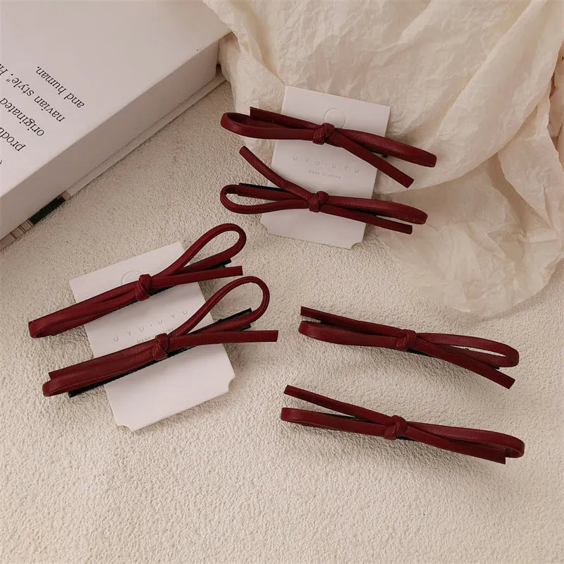 Wine red genuine leather bow hair clip barrette on a white background.