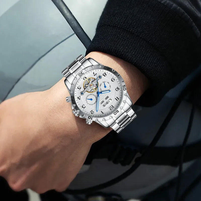 Silver men's automatic perpetual calendar mechanical watch with stainless steel strap on a wrist.