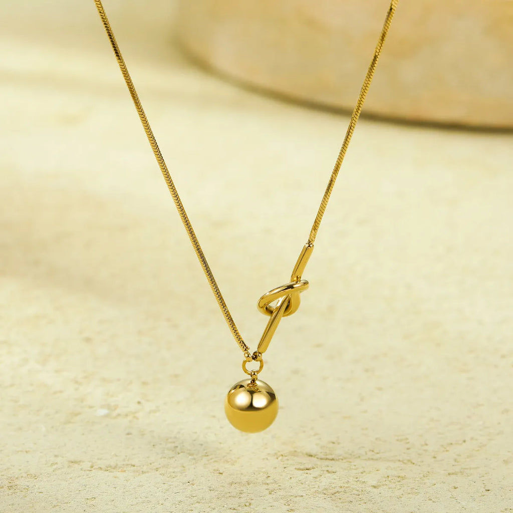 18K gold plated stainless steel winding ball pendant necklace for women on a white background