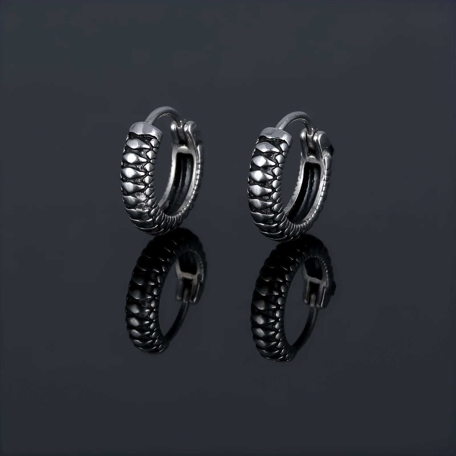 Silver geometric alloy earrings with circular stripe design on a white background.