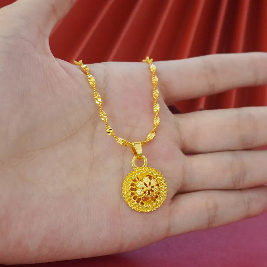 Gold-plated jewellery three-piece set with flower design pendant, matching earrings, and ring on display