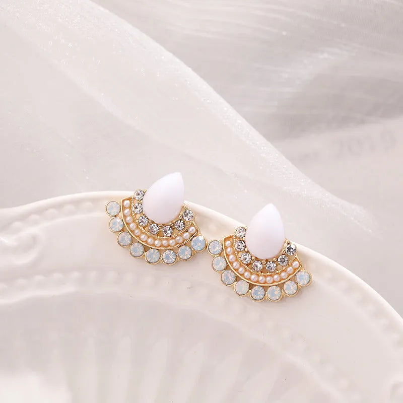 Women's silver retro fan-shaped earrings with opal and rhinestone details on a white background.