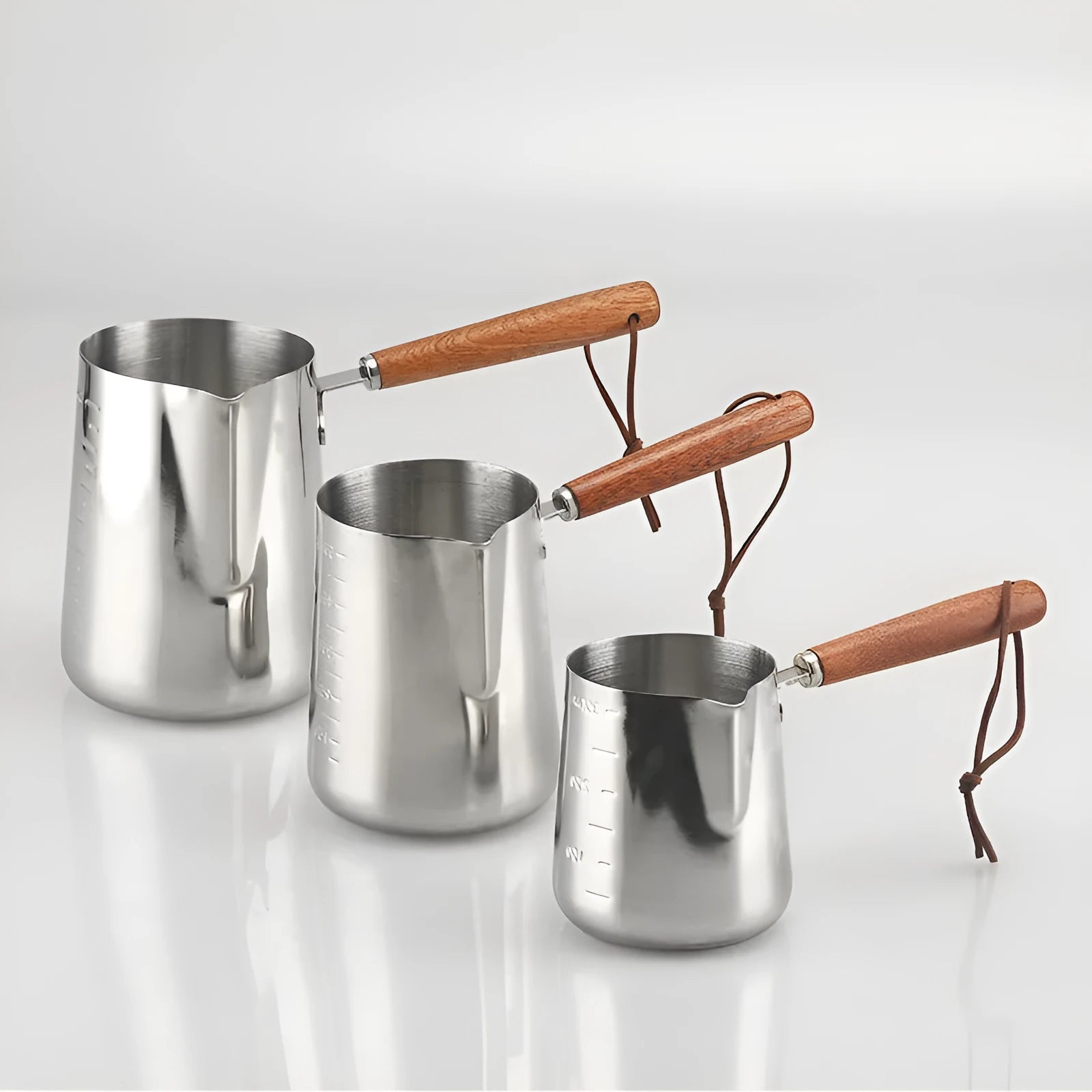 Stainless steel latte art milk frothing jug with measurement scale and wooden handle