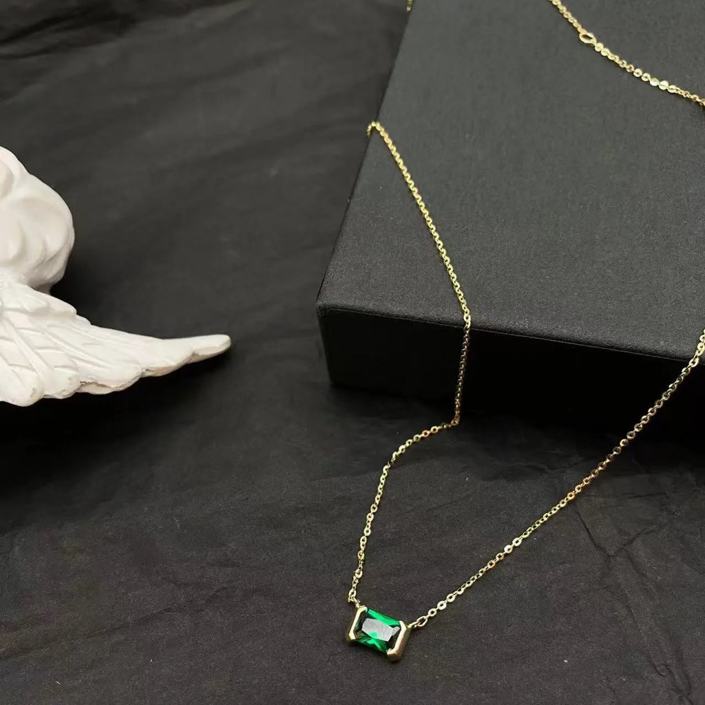 Gold-coloured geometric quadrilateral pendant necklace on a model, showing Lvzuan inlay detail on copper.