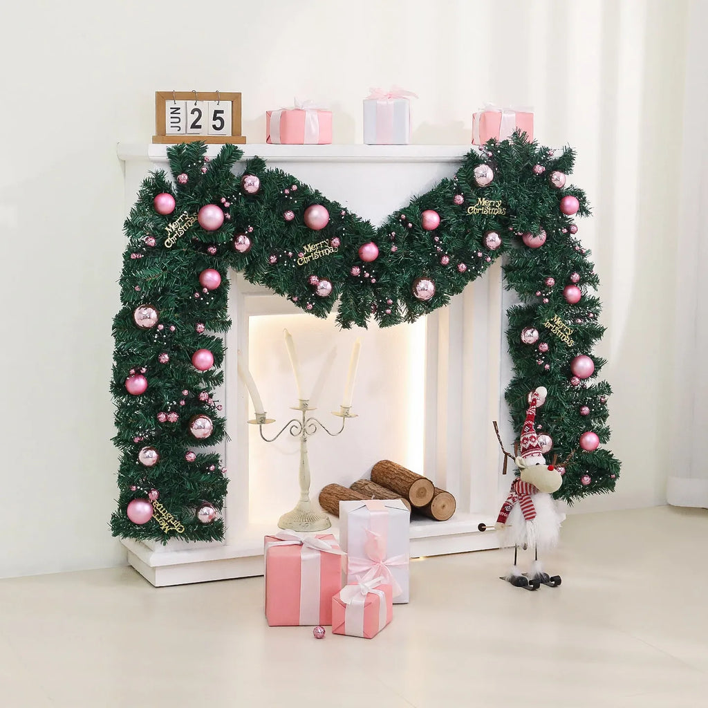 Pink artificial Christmas rattan vine decoration with small fruit clusters and warm white LED lights, coiled on a table.