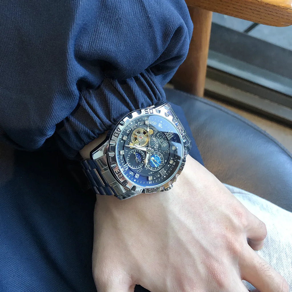 Men's silver case automatic watch with black steel strap and luminous dial.