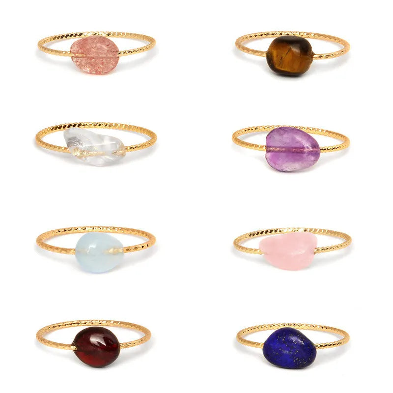 A geometric silver-toned ring setting holding a polished oval agate stone in a blue-green colour.