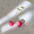 A pair of acrylic peach fruit earrings on a copper post, showing small and large size options.