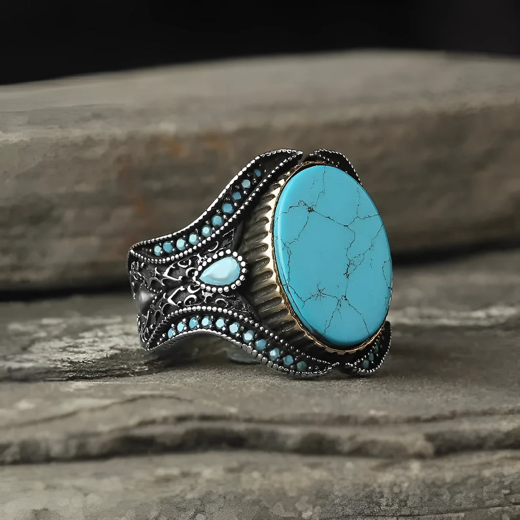 Men's antique silver ring with turquoise accent on finger showing simple round design