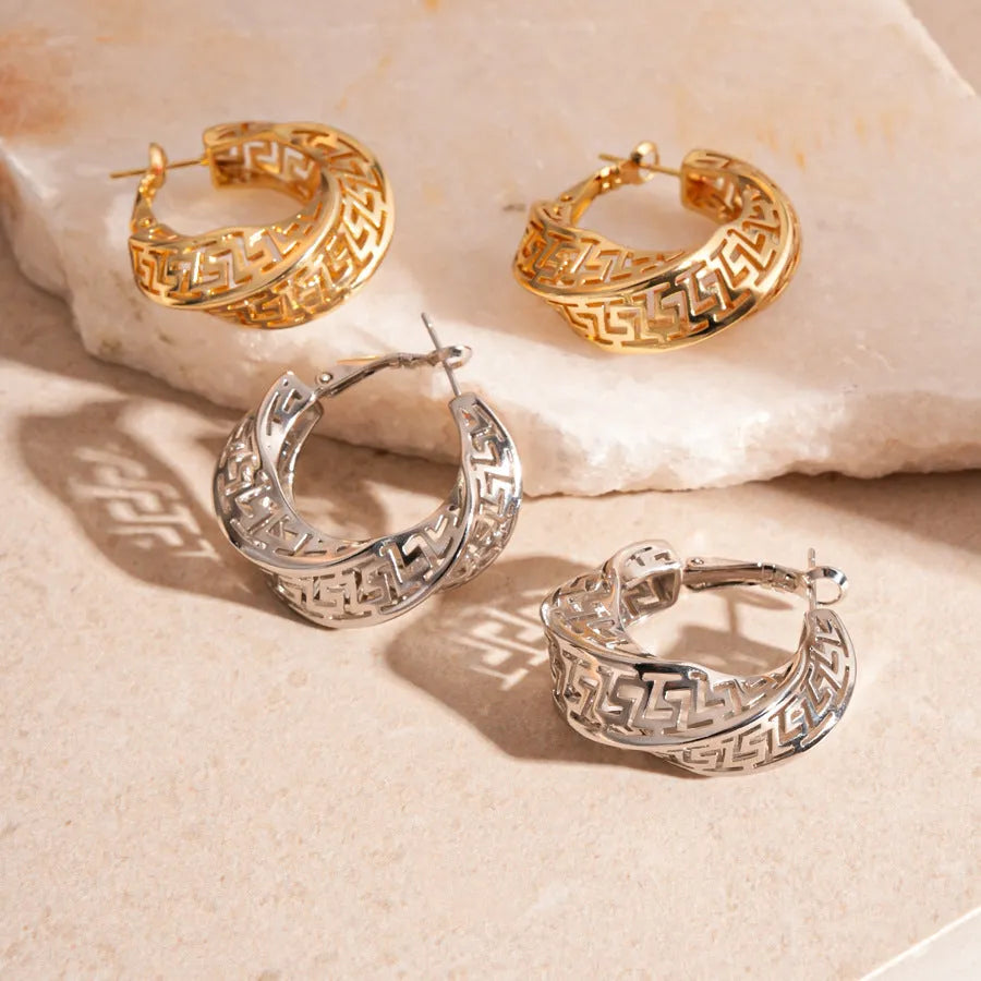 A pair of twisted round geometric hollow stud earrings in a silver electroplated finish.
