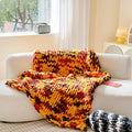Handmade thick chenille striped blanket in a choice of four colours on a bed.