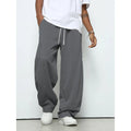 Man wearing grey micro-elastic casual trousers with a drawstring waist and straight leg.