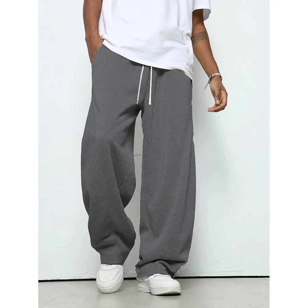 Man wearing grey micro-elastic casual trousers with a drawstring waist and straight leg.