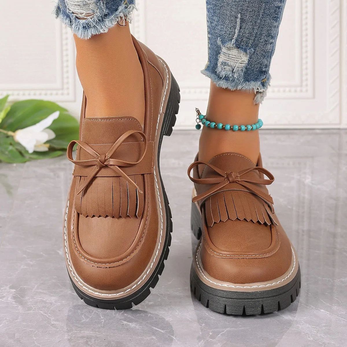 Black plus size women's loafers with tassel detail, bowknot, and a chunky low heel.