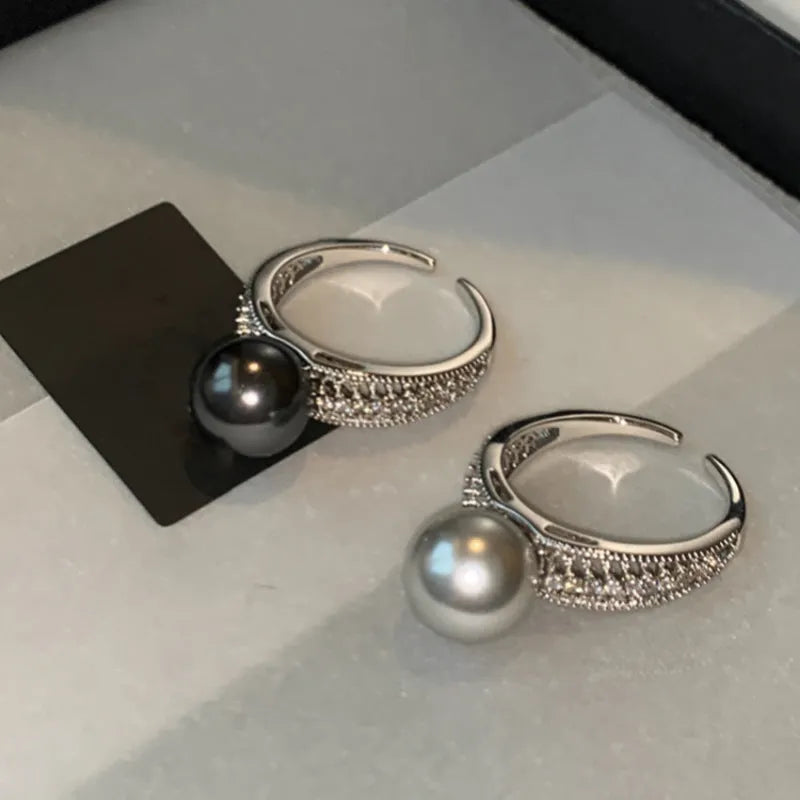 Adjustable open geometric copper ring for women with a small black pearl accent on the band.