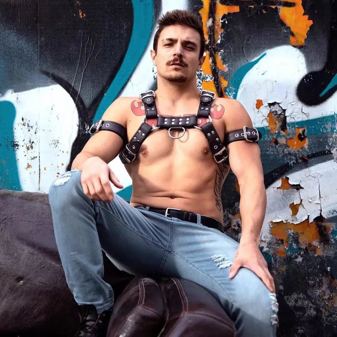 Black leather chest bondage strap with metal buckle and rivet detail on a mannequin