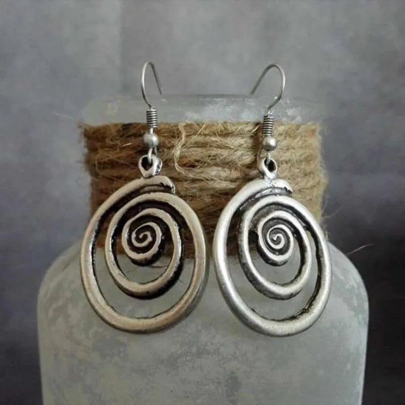 A pair of retro-style geometric spiral earrings with a distressed silver finish.