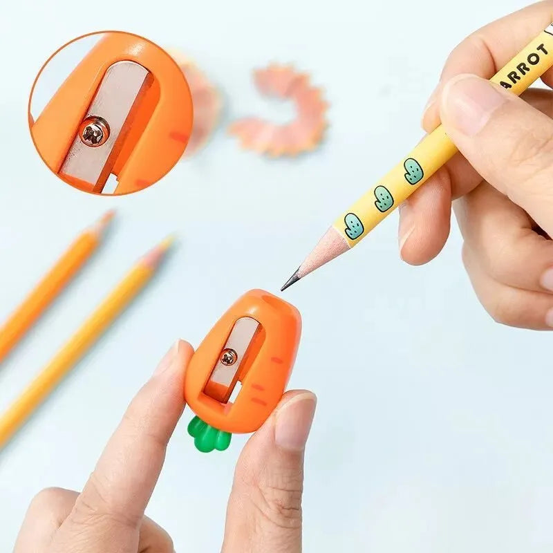 Four fruit and vegetable shaped mini pencil sharpeners in random colours on a light surface