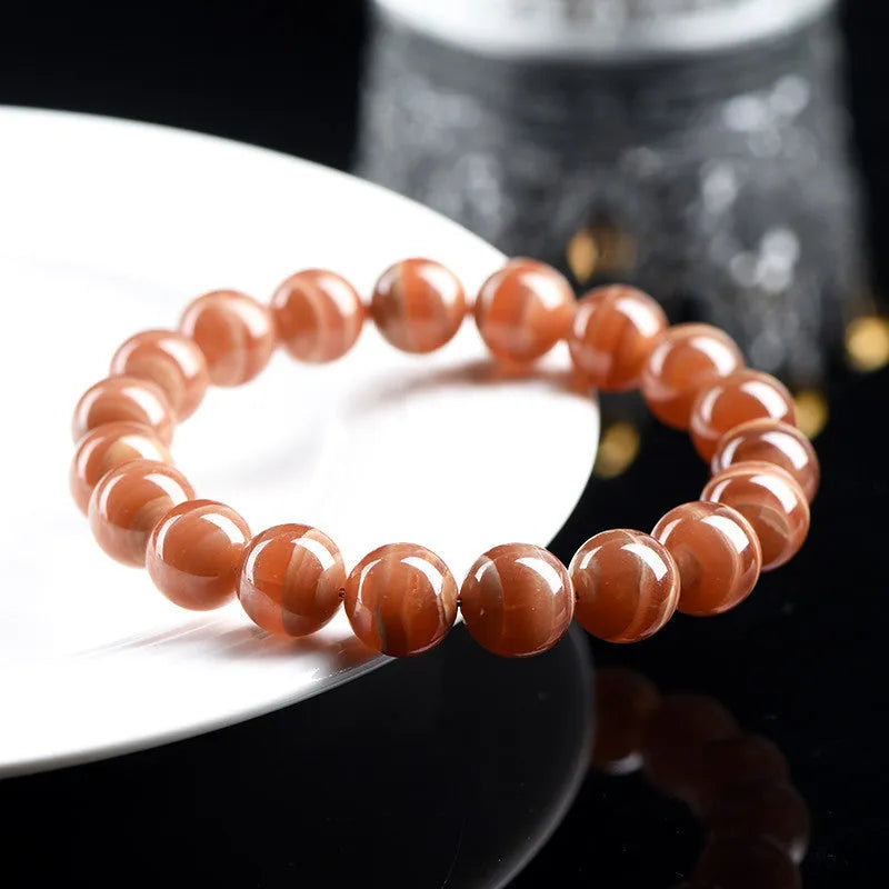 Natural old mine rhodochrosite round bead bracelet with Ruyi charm, shown in 6mm and 8mm sizes.