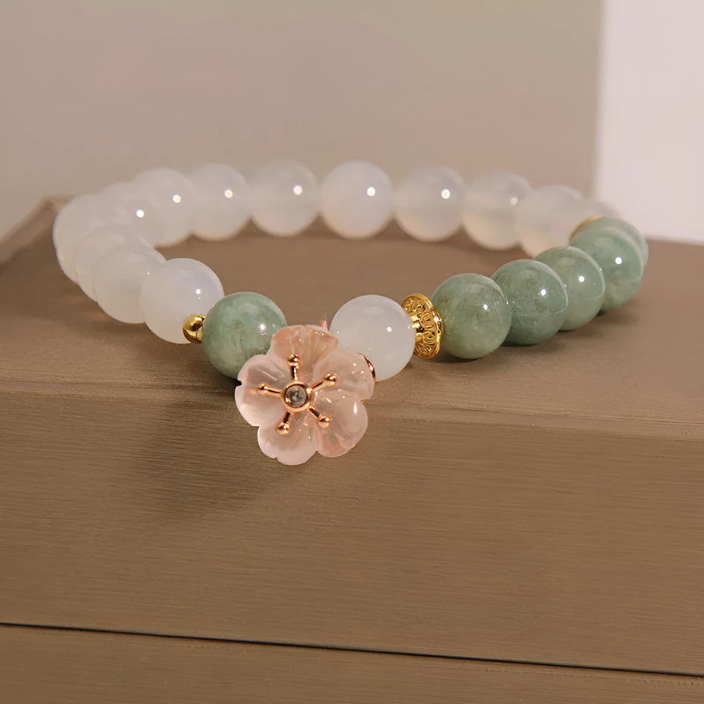 Emerald agate bracelet with white jade flower beads and pink accents on wrist