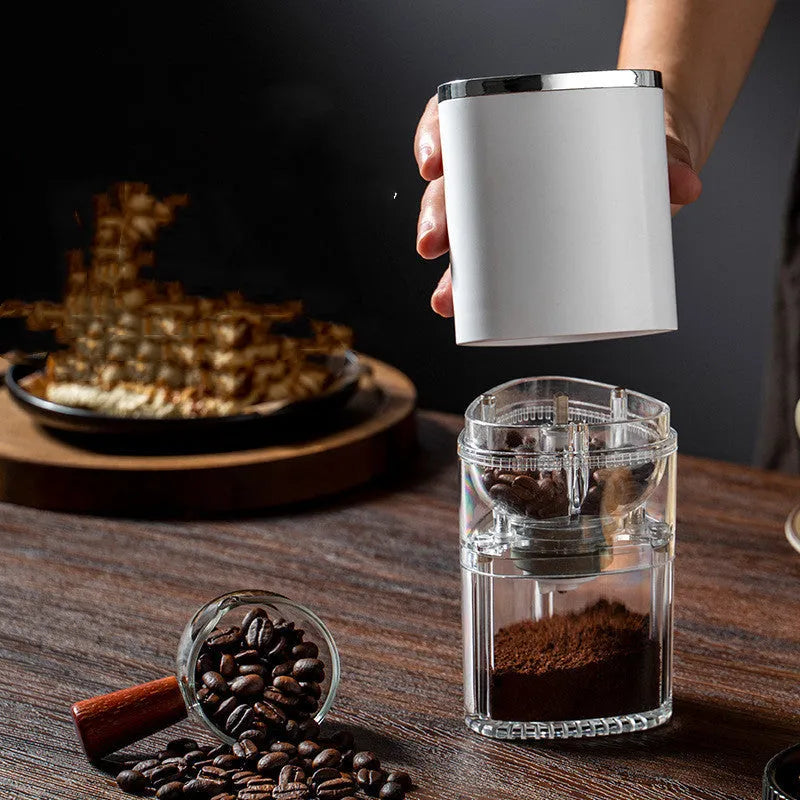 Portable white electric coffee grinder with USB charging cable and ground coffee