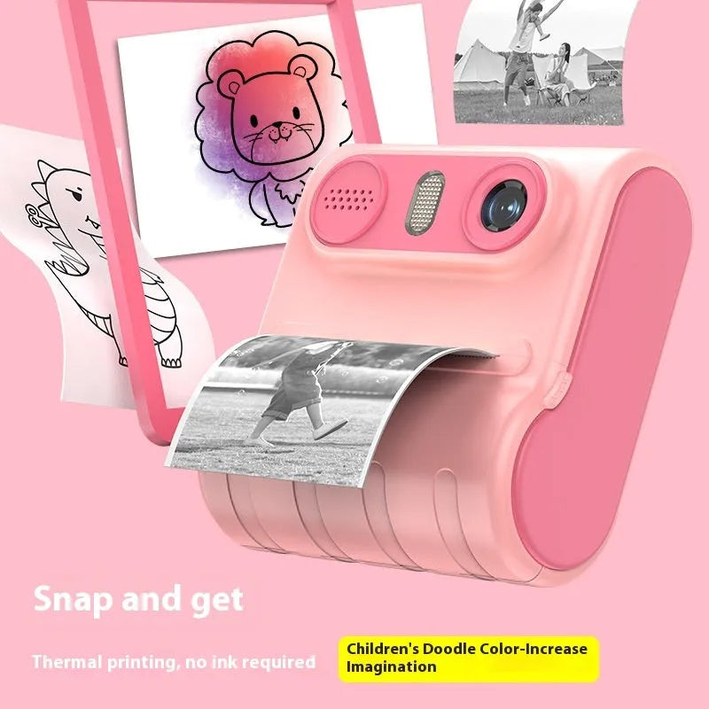 Children's instant thermal printing camera in pink with dual lenses, including lanyard and charging cable on white background
