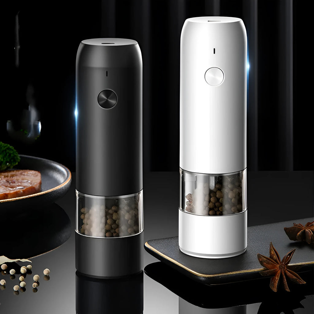 Black and white electric salt and pepper grinder set with USB charging cable on a kitchen worktop.