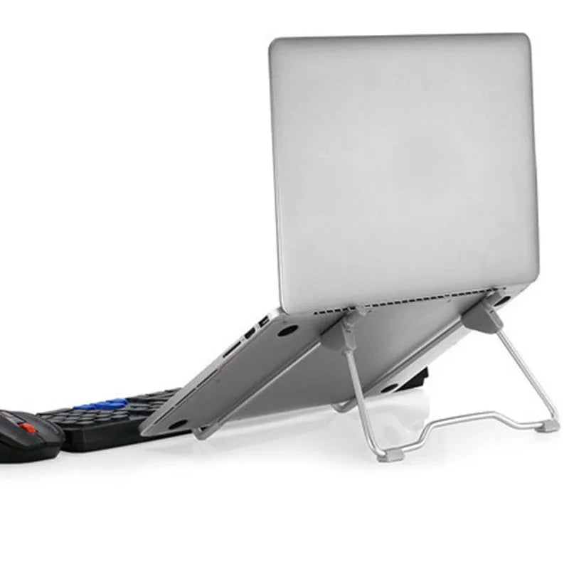 Grey foldable aluminium and plastic stand holding a mobile phone and a laptop on a desk.