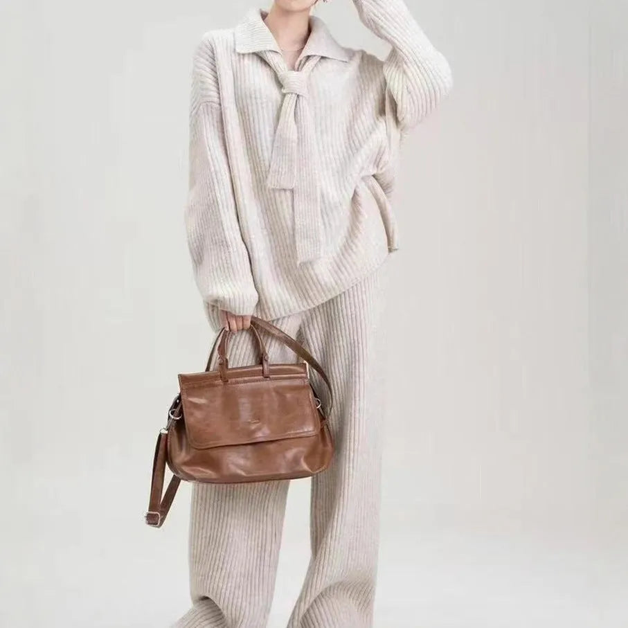 Women's dark grey acrylic knit sweater suit two-piece set with long sleeves and casual trousers.