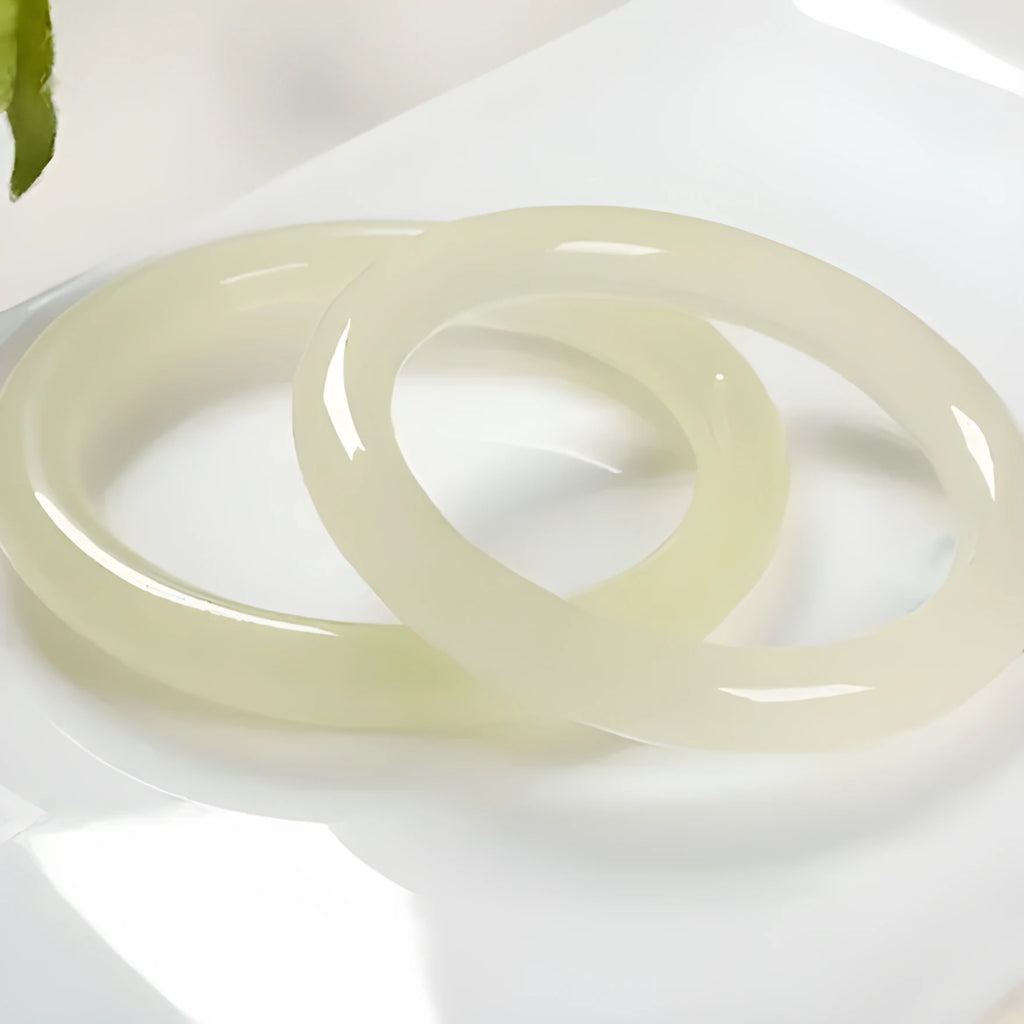 Ice-like silk jade round bar bracelet showing geometric winding design on a wrist.