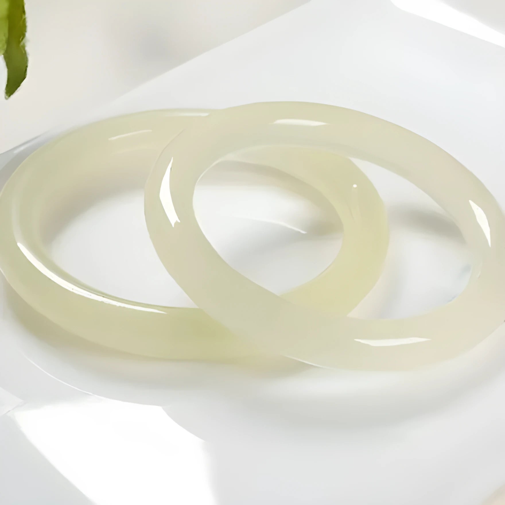Ice-like silk jade round bar bracelet showing geometric winding design on a wrist.
