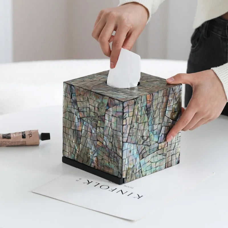 Black rectangular and square natural shell tissue box storage holder on a coffee table.
