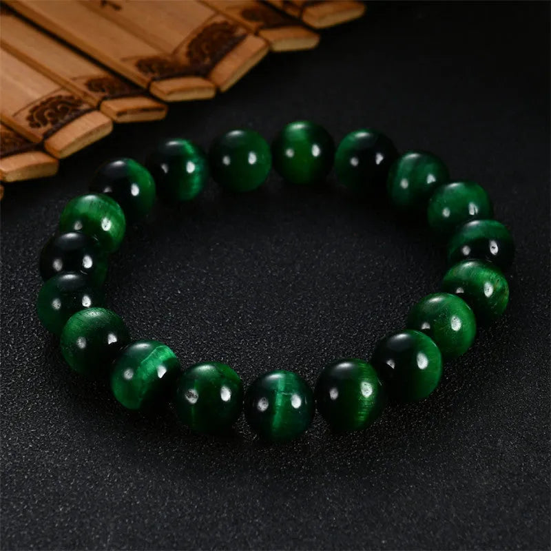 Green Tiger Eye stone beaded bracelet with polished geometric beads on a white background.