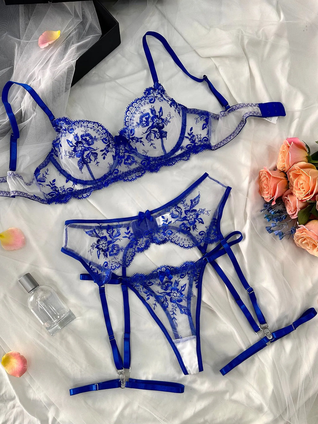 Women's embroidered underwear set with see-through mesh cutouts and matching garters in sapphire blue.