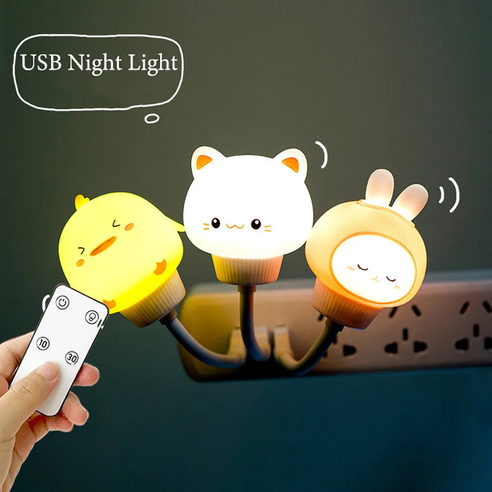 USB portable cartoon animal LED night light with remote control on a bedside table.
