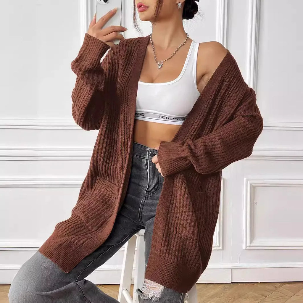 A woman's loose-fit mid-length cardigan in a solid colour, shown on a hanger.