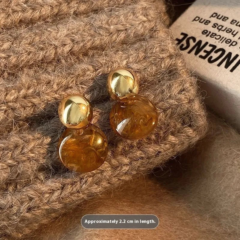 Set of three geometric alloy earrings with tassel detailing in gold, amber and tiger eye colours