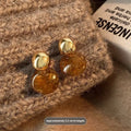 Set of three geometric alloy earrings with tassel detailing in gold, amber and tiger eye colours