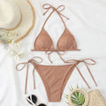 Women's split bandage style bikini swimsuit in polyester fabric on a mannequin.