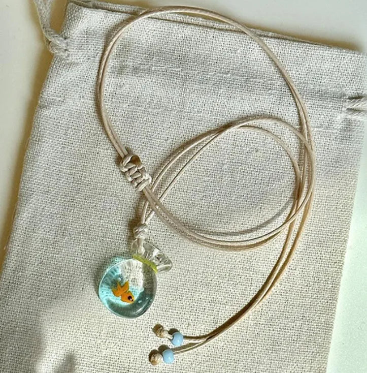 Women's pendant necklace with a coloured glaze skirt-shaped joker charm on a cotton and linen clavicle chain.