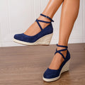 Dark blue straw woven wedge closed toe high heels with buckle fastening on a light background