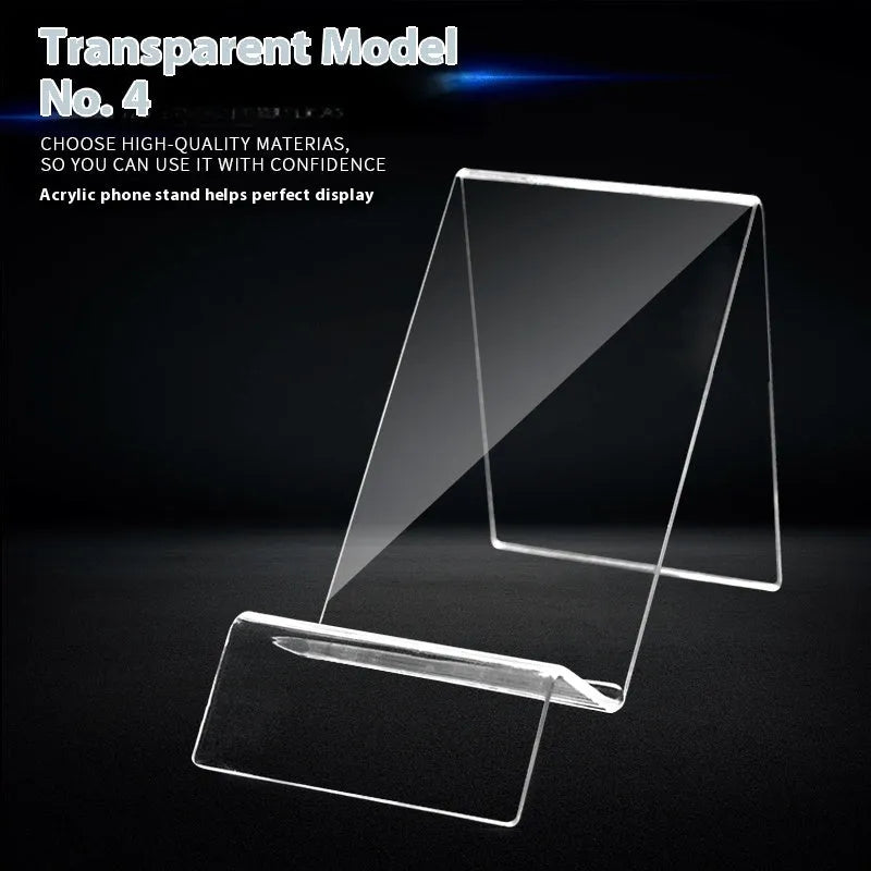 Clear acrylic mobile phone stand on a desk with a smartphone placed in it, showing the universal fit and transparent design.