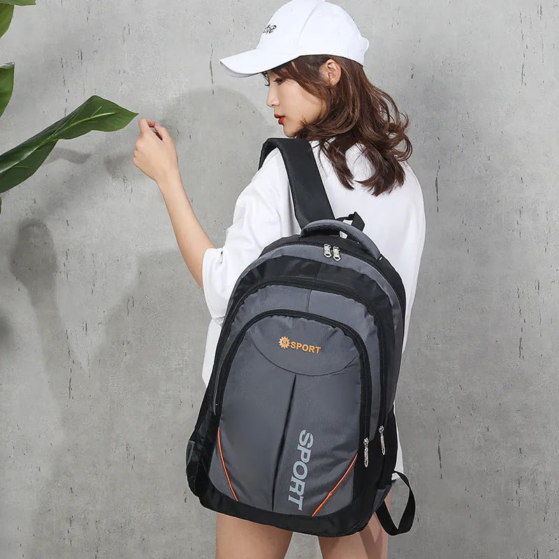 Large nylon backpack in black with curved shoulder straps and letter detailing, showing front compartment