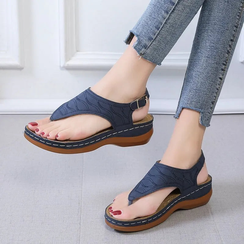 Women's red wedge heel sandals with an adjustable back strap buckle.