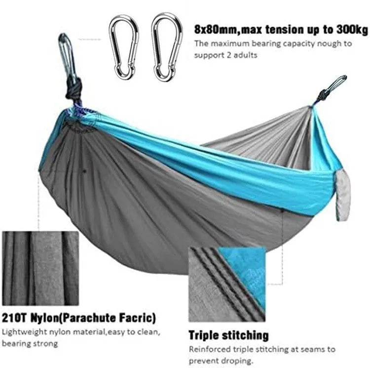 Blue parachute nylon outdoor hammock hung between two trees in a garden setting