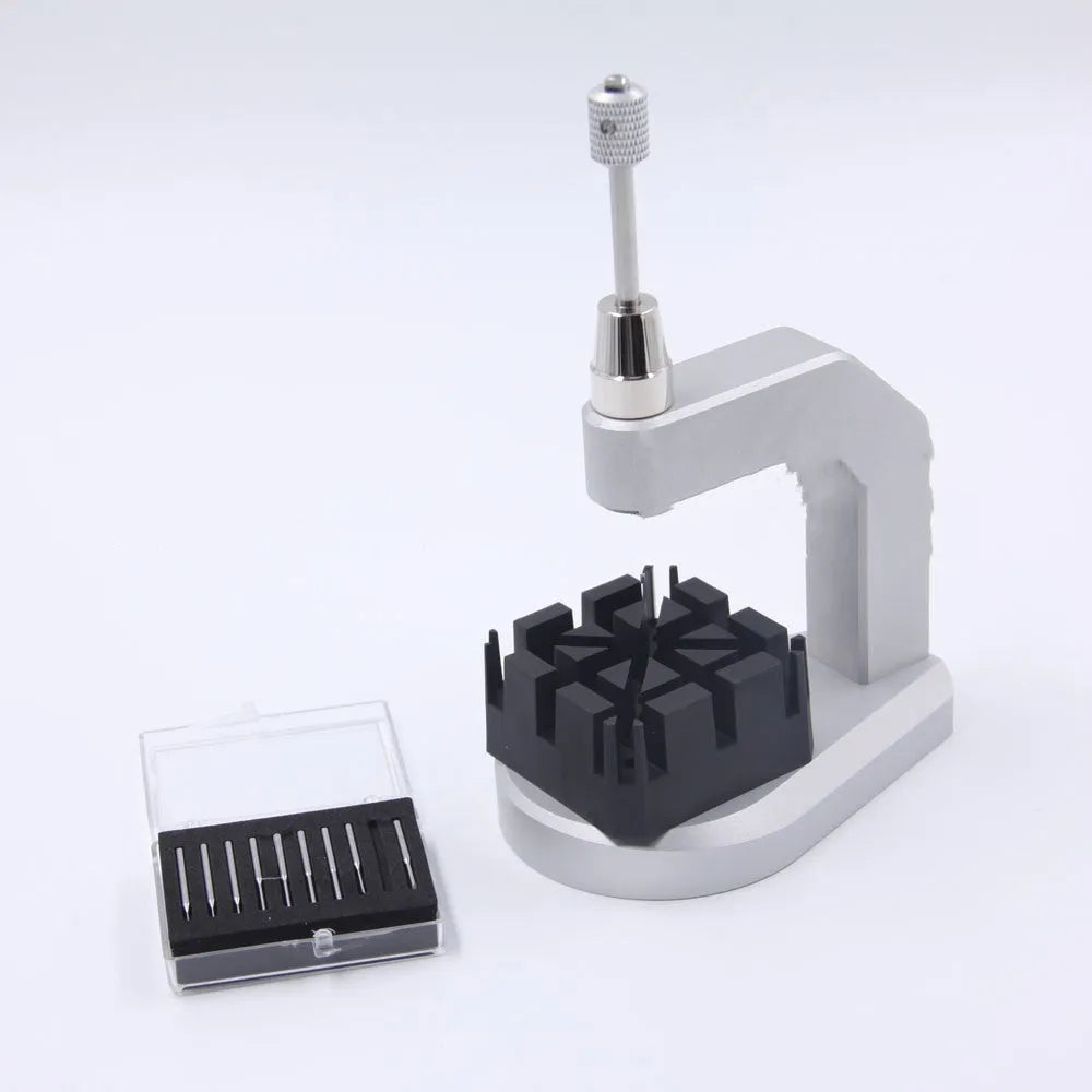 Silver tool steel multi-purpose press strap removal tool on a work surface.