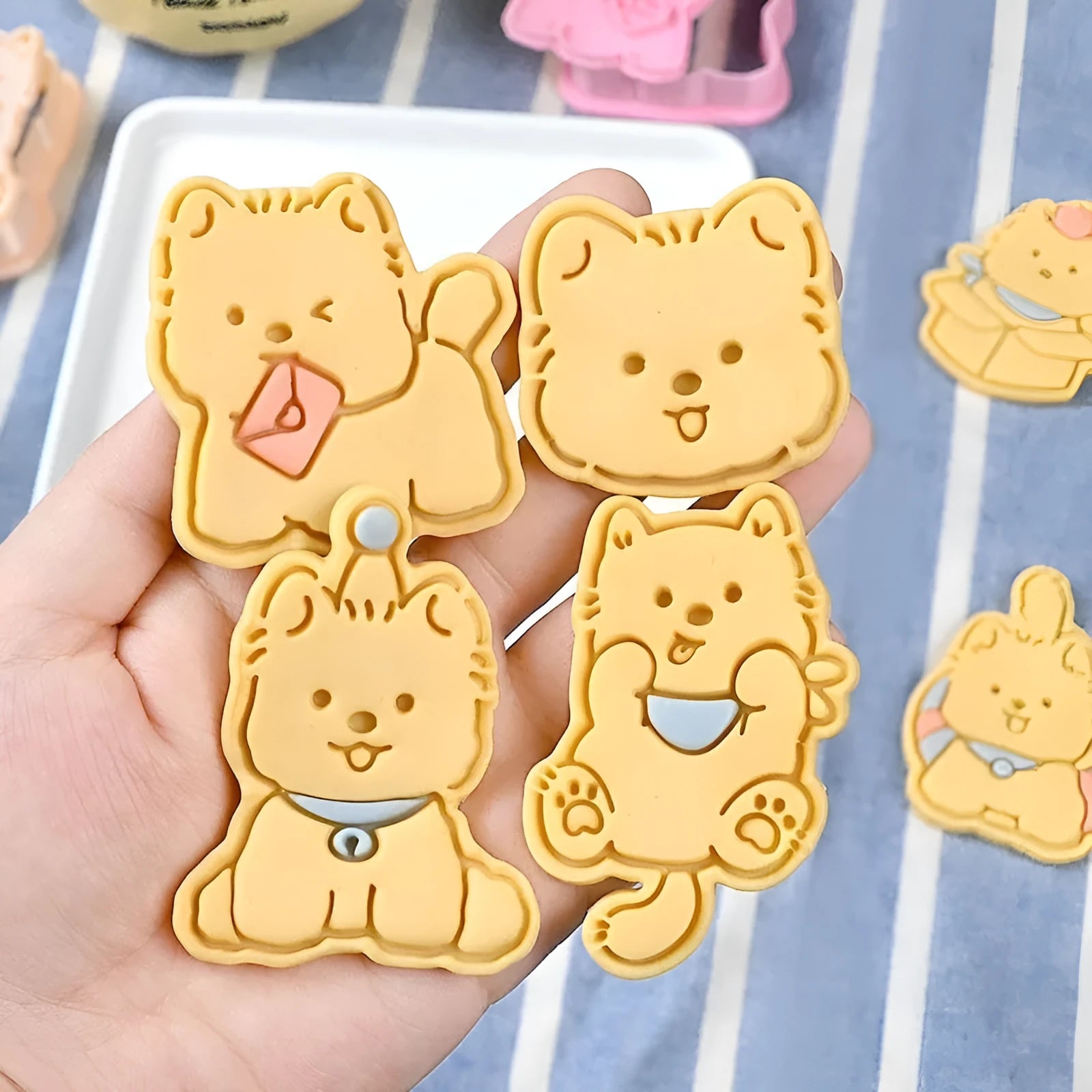 Plastic cartoon biscuit mould showing three-dimensional pet puppy designs including one with a birthday hat