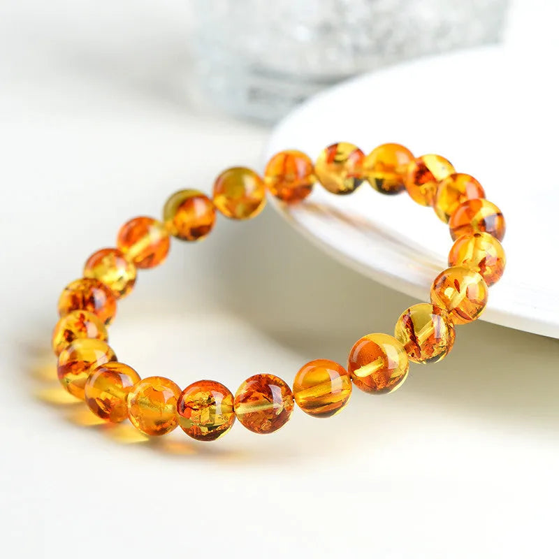 Natural yellow piebald amber bracelet with geometric beads on a wrist.